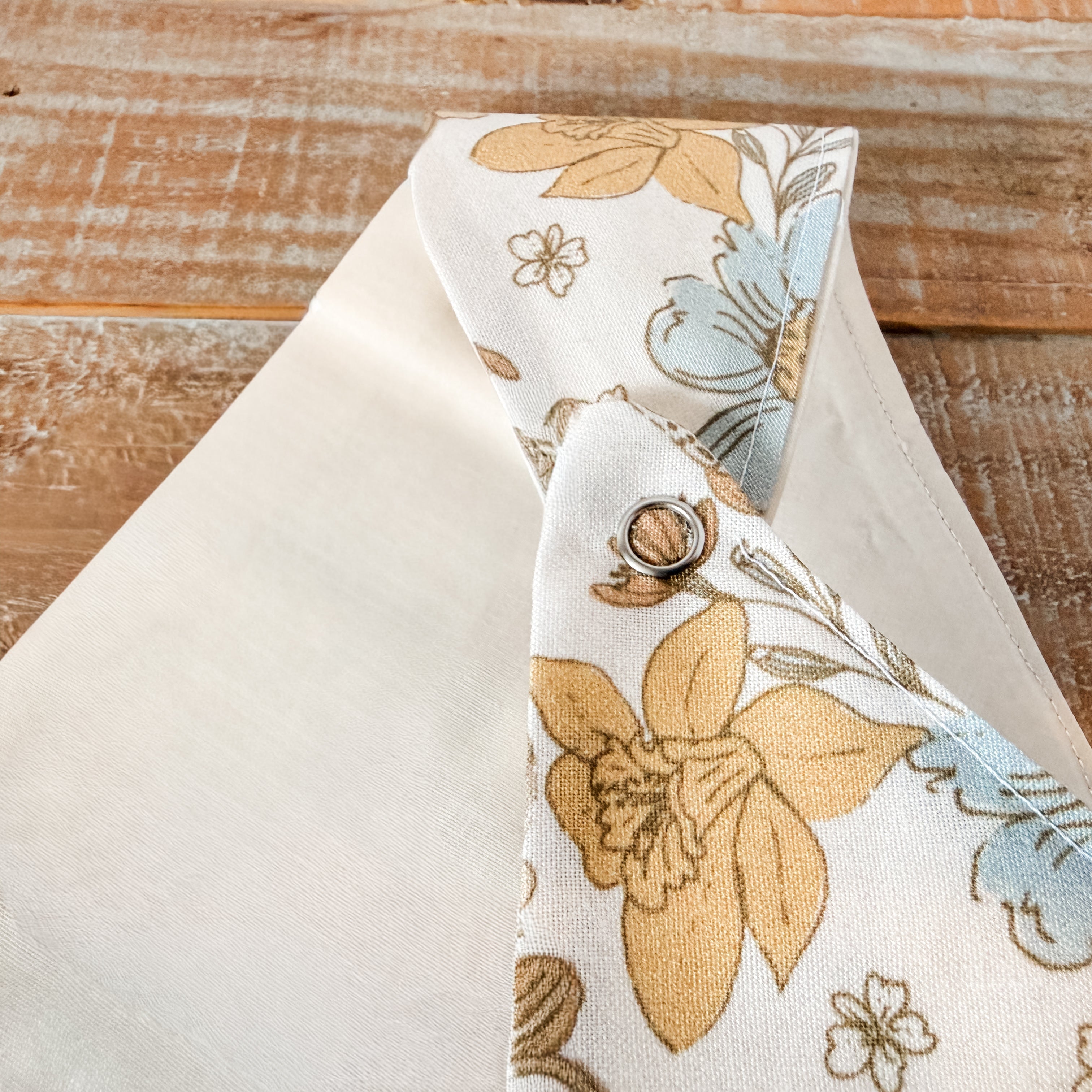 Floral-patterned bow tie on a wooden surface