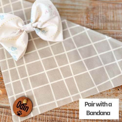 White bow with blue patterns on a beige checkered fabric, branded 'Odin'.