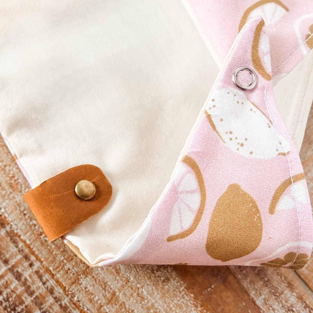 Fabric with pink and gold pattern on a wooden surface