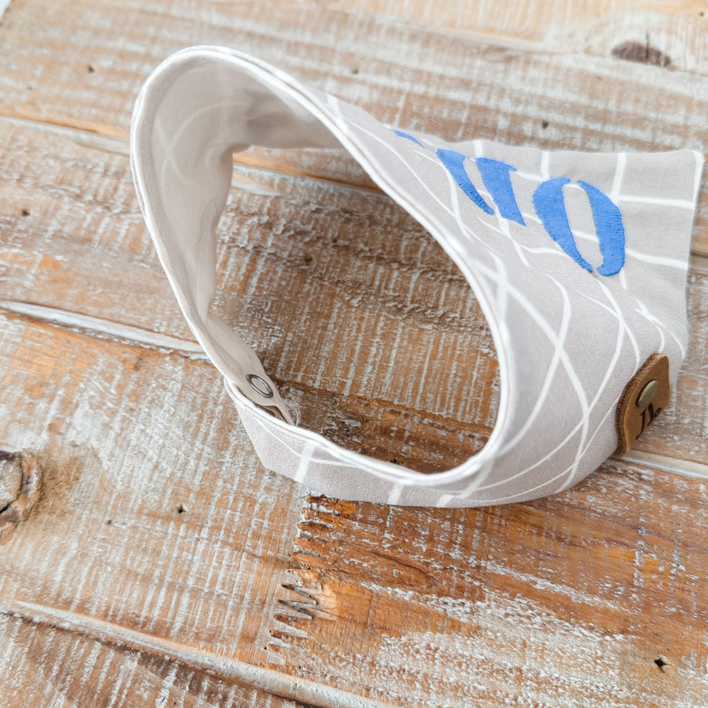 White visor with blue text on a wooden surface