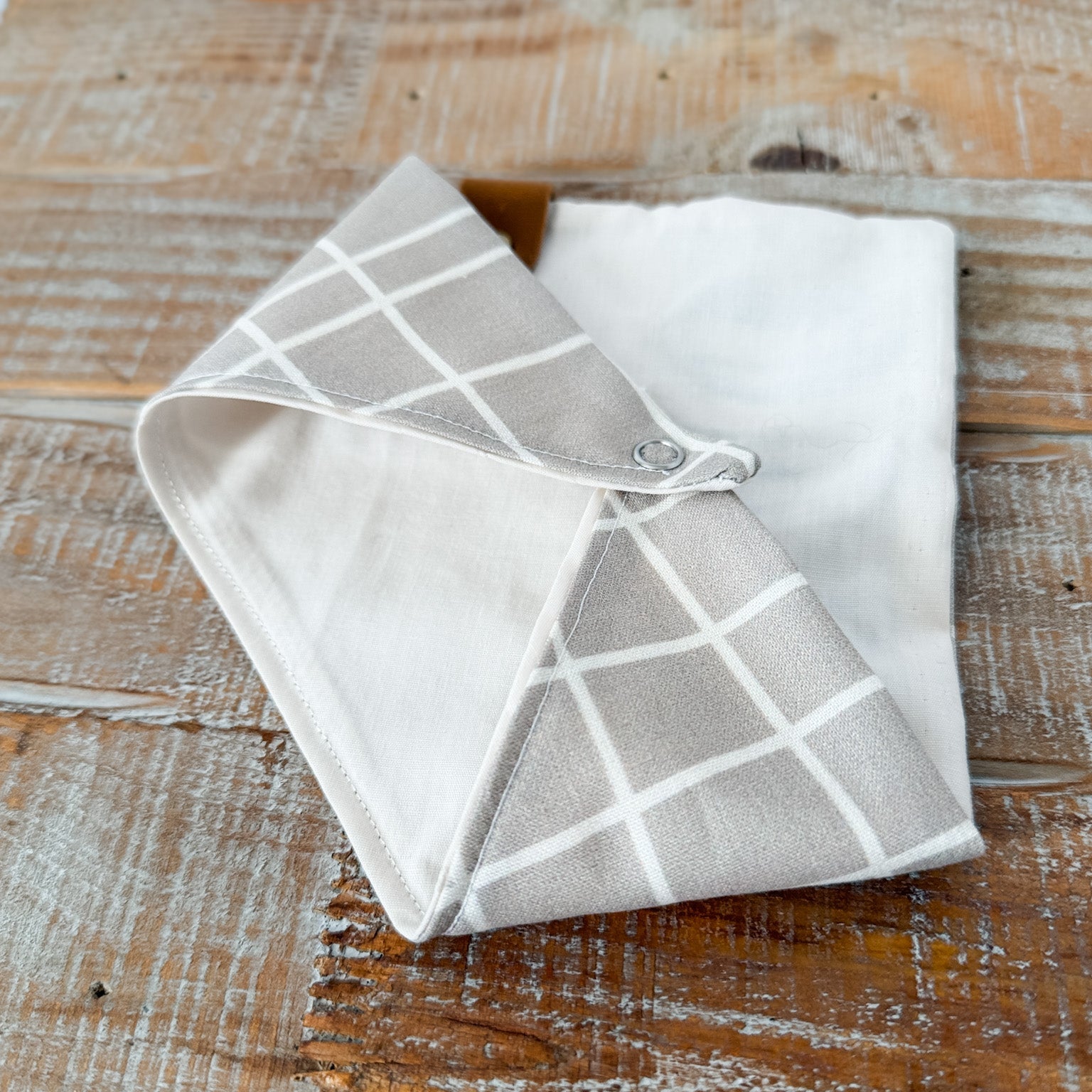 Folded fabric with a grid pattern on a wooden surface