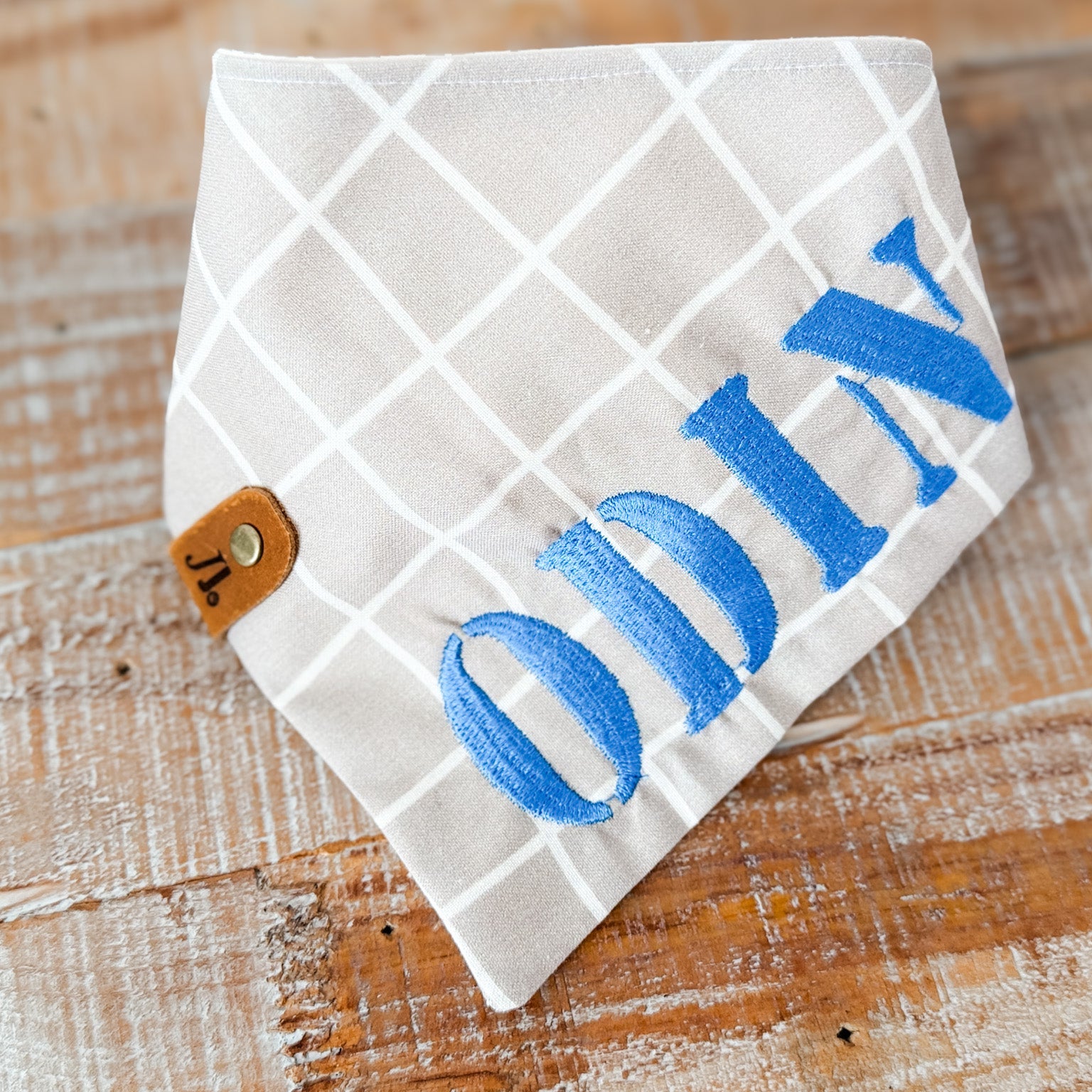 White quilted pouch with blue 'DIY' text on a wooden surface