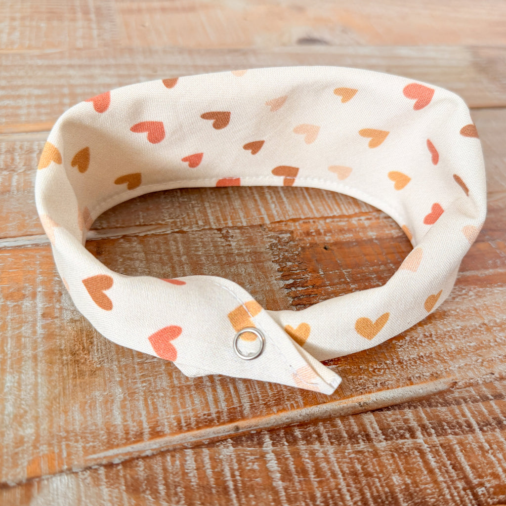 White bandana with heart patterns on a wooden surface