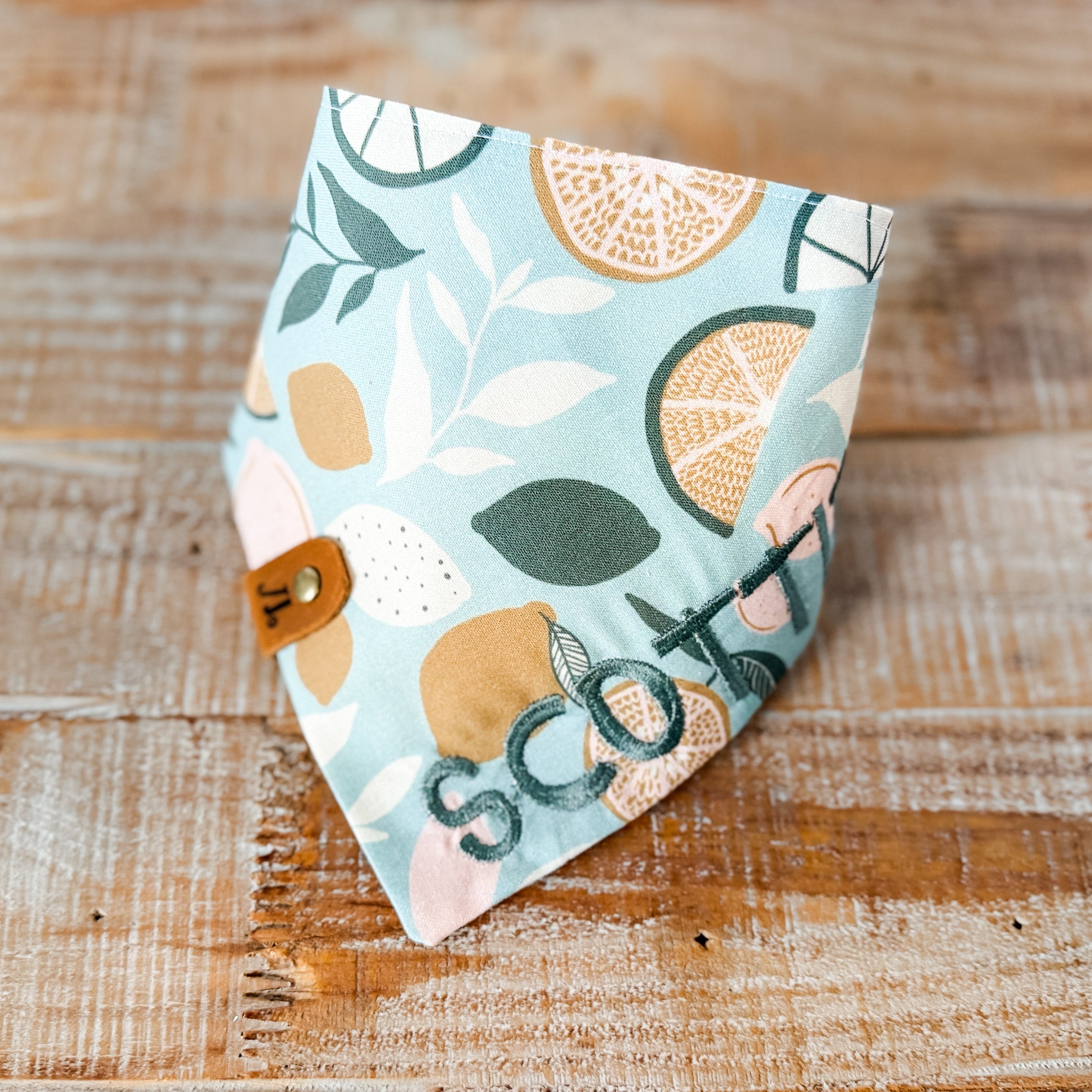 Fabric with fruit pattern and 'Scott' text on a wooden surface