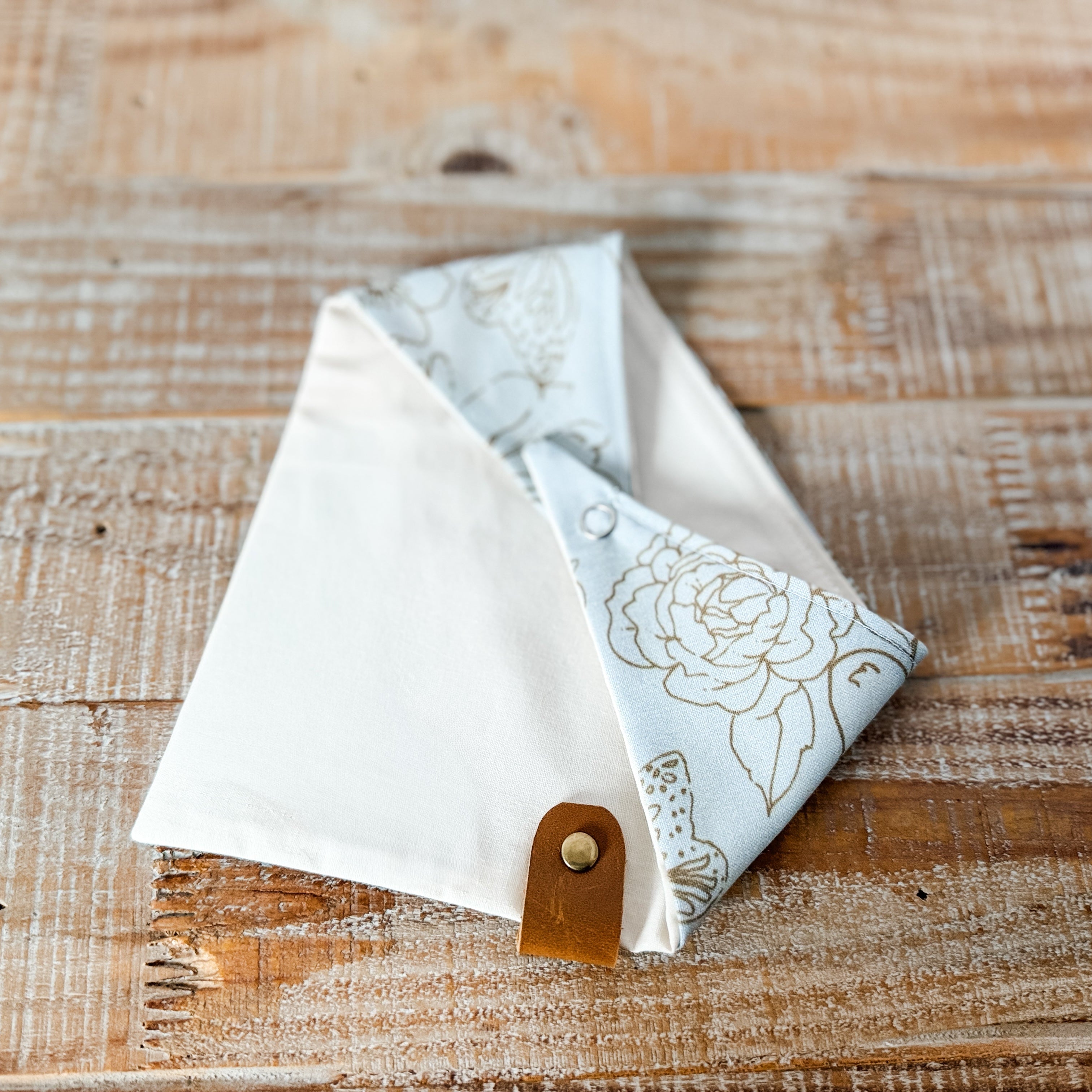 Two fabric triangles with floral patterns on a wooden surface