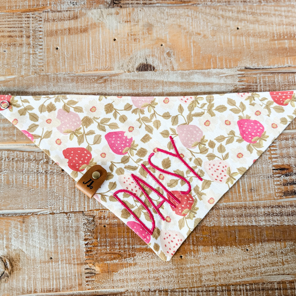 Floral patterned bandana with 'Mia' printed on it, placed on a wooden surface.