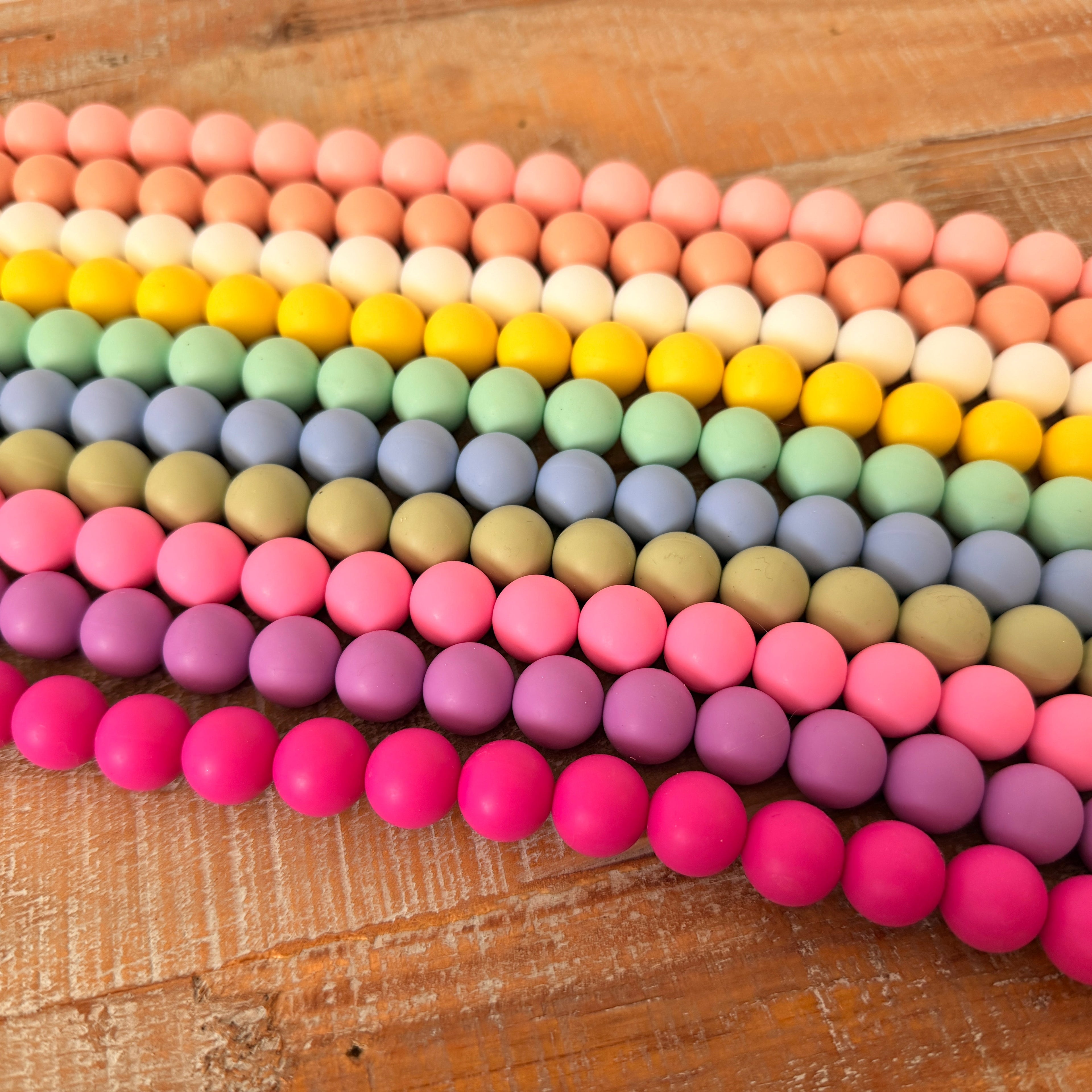 Colorful beaded bracelets arranged on a wooden surface