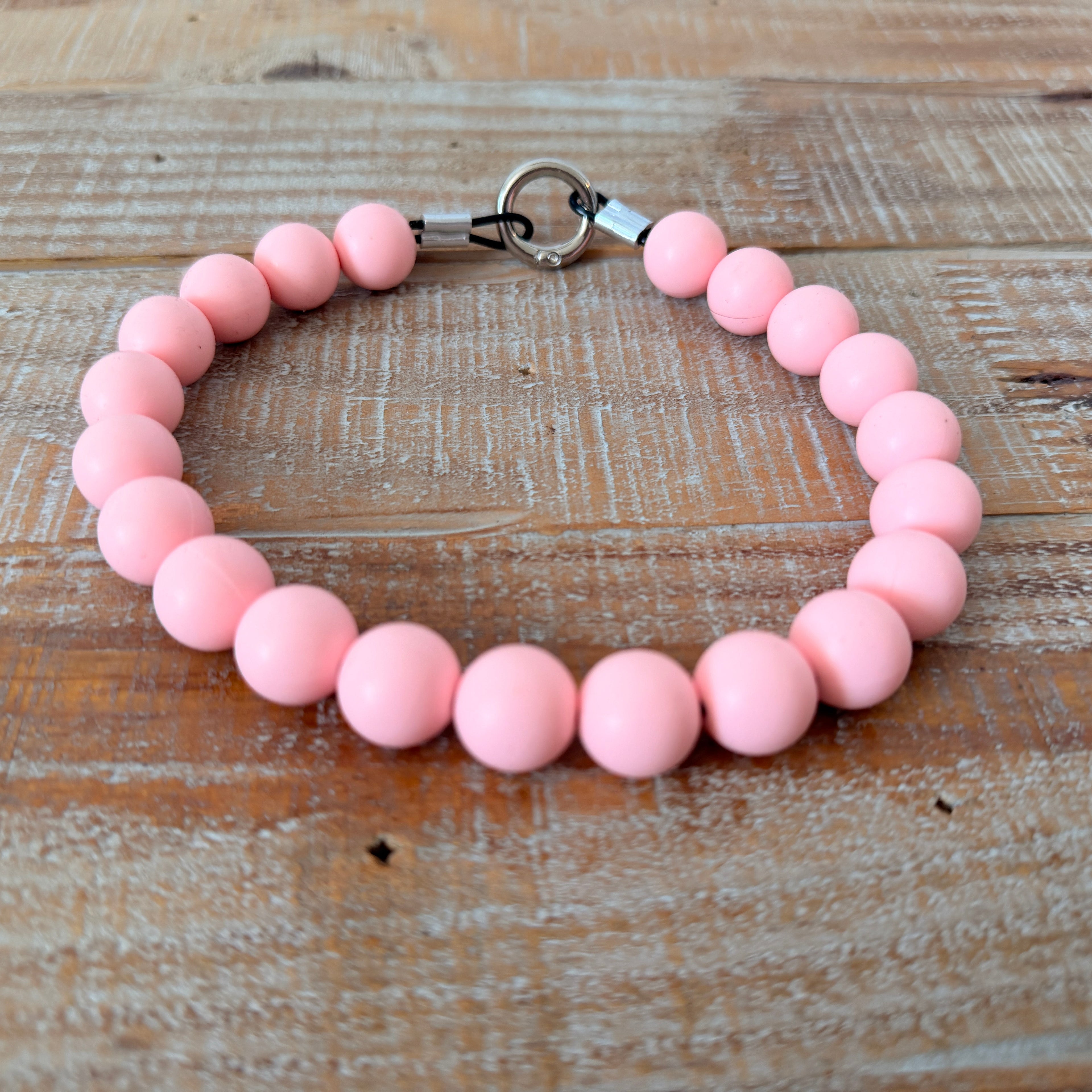 Pink beaded bracelet on a wooden surface